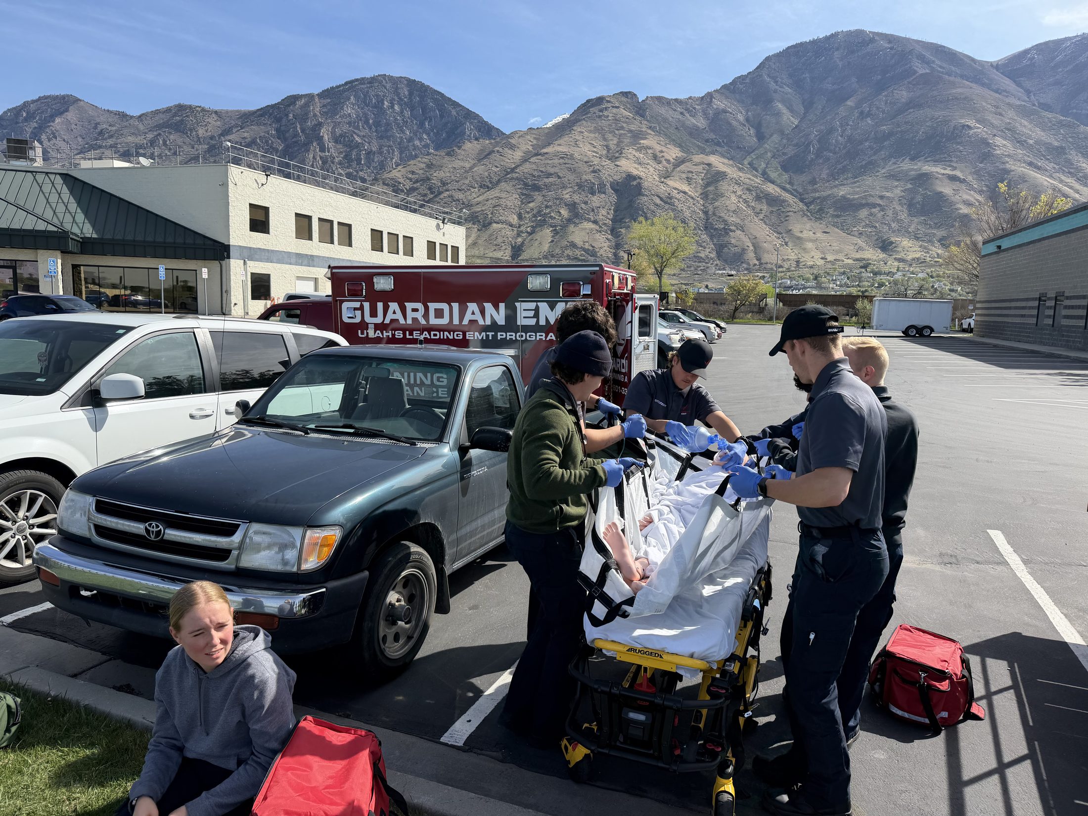 Guardian EMT students running a parking lot mock code with coordinated team response